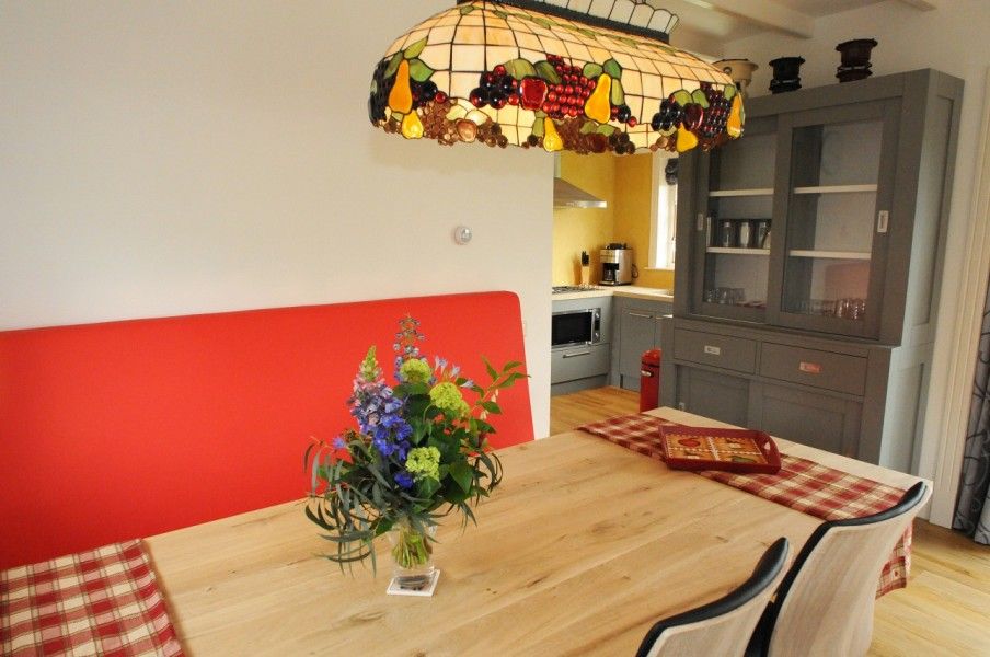 Eethoek met kleurrijke lamp in vakantiehuis Sonja, Texel, ideaal voor familiediners.