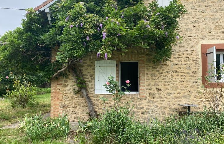 Authentiek stenen vakantiehuis in Morcenx, Aquitaine met groene omgeving en kleurrijke bloemenpracht.