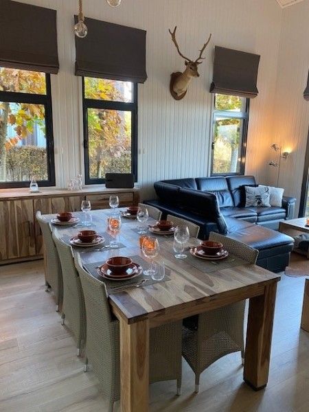 Gezellige eetkamer in Dogo In Paradise vakantiehuis, Houffalize, Ardennen, met houten tafel en herfstdecoratie.