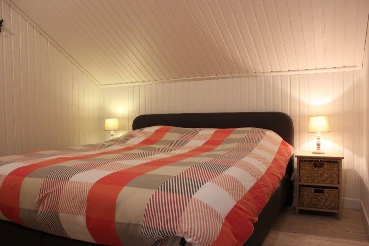 Knusse slaapkamer in Dogo In Paradise vakantiehuis, Houffalize, Ardennen, met groot tweepersoonsbed en warme verlichting.