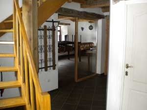 Binnenruimte van Het Huis Hiernaast, vakantiehuis in Houffalize, met houten trap.