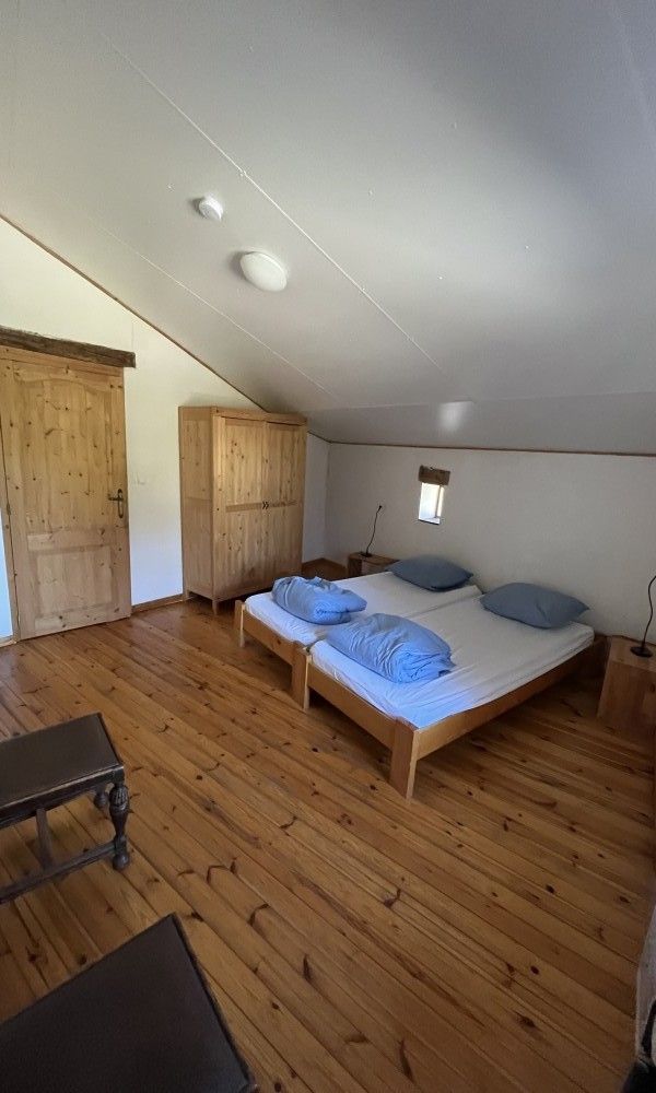 Knusse slaapkamer met houten vloer in Het Huis Hiernaast, vakantiehuis in Houffalize, Ardennen.