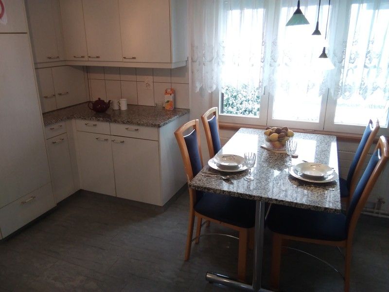 Keuken en eetgedeelte van Hauschen accommodatie in Winikon, Zwitserland, met ramen naar de omgeving.