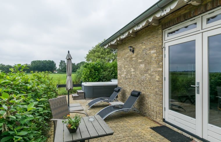 Porch of Cottage in Allingawier with deck chairs and view of Frisian woods in Friesland.