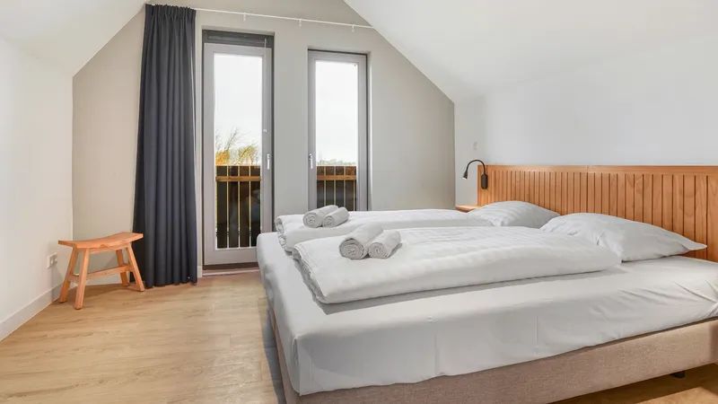Ruime slaapkamer met balkon in 6-persoons woning 6C, vakantiehuis in Witmarsum, Friesland.