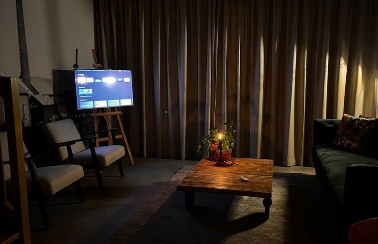 Sfeervolle woonkamer van Vakantiehuisje in Lioessens met avondverlichting, Friesland, op het platteland.