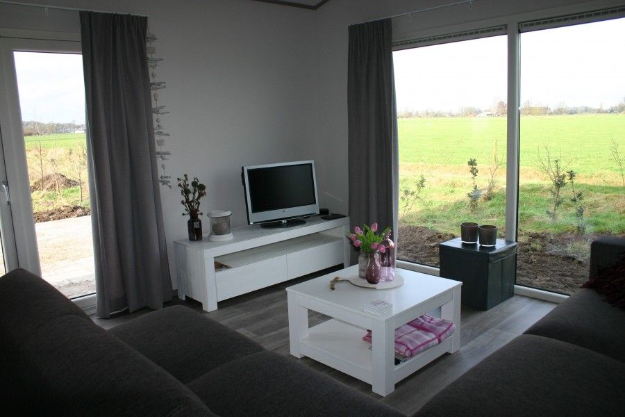 Gezellige woonkamer met uitzicht op de Veluwe bij Van Luttikhuizen chaletverhuur Zwaantje 1 in Teuge. Ideaal voor ontspanning.