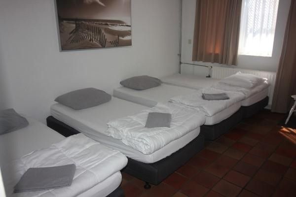 Ruime slaapkamer met meerdere bedden in Vakantiehuis Giethoorn, ideaal voor families in Giethoorn, Overijssel.