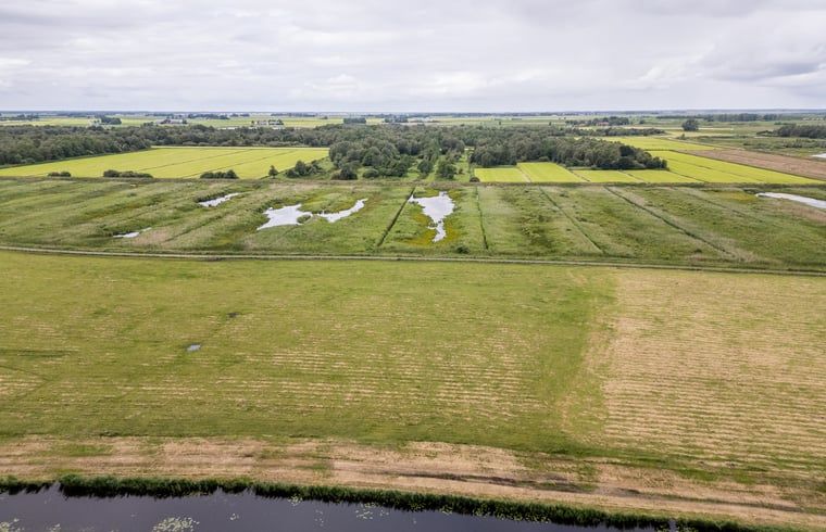 Uitgestrekte velden rondom Vakantiehuisje in Wetering, Noordwest Overijssel met waterpartijen.