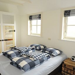 Slaapkamer in vakantiehuis Sonja, Den Hoorn, Texel met rustieke kledingkast.