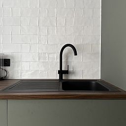 Moderne keuken in Villa Frans Luxe Appartement, Oostende, met strakke gootsteen en elegante tegels.