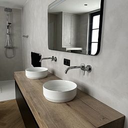 Luxe badkamer in Villa Frans Luxe Appartement, Oostende, met dubbele wastafel en grote spiegel.