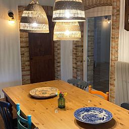 Binnenruimte van Vakantiehuis in Morcenx, Frankrijk, met uitnodigende eettafel en warme verlichting.