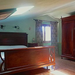 Knusse slaapkamer in Vakantiehuisje in Santa Fiora, Toscane, met antieke houten meubels voor een ontspannen verblijf.