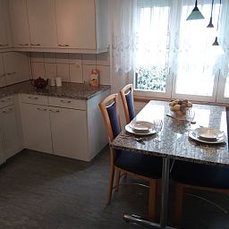 Keuken en eetgedeelte van Hauschen accommodatie in Winikon, Zwitserland, met ramen naar de omgeving.