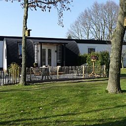 Vakantiehuis in Hoogeveen omgeven door weelderig gras en bomen in Drenthe.