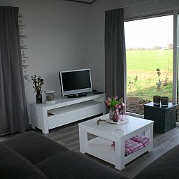 Gezellige woonkamer met uitzicht op de Veluwe bij Van Luttikhuizen chaletverhuur Zwaantje 1 in Teuge. Ideaal voor ontspanning.