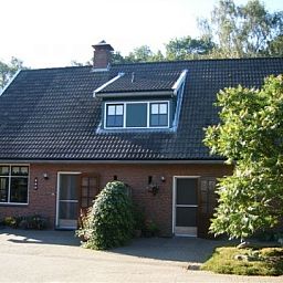 Charmante voorgevel van Huize Ruhenberg vakantiehuis in Overdinkel, Twente, met groene omgeving.