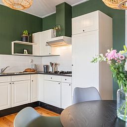 Eethoek in Vakantiehuis in Wetering, Overijssel met design stoelen en houten vloer.