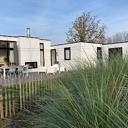 Geniessen Sie die moderne Veranda im BreskensBeachhouse B66, einem Chalet in Breskens, Zeeuws-Vlaanderen, umgeben von Naturschoenheiten.