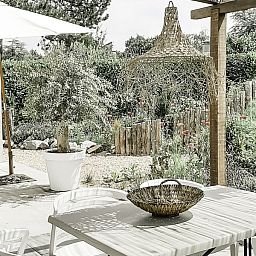 Buitenterras van Casa Pueblo Viejo in Ouddorp, vakantiehuis met tuinzicht in Zuid-Holland.