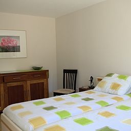 Ruime slaapkamer in Kussengevecht Duinvilla, Den Haag, vakantiehuis aan de Noordzeekust met tweepersoonsbed en houten meubelen.