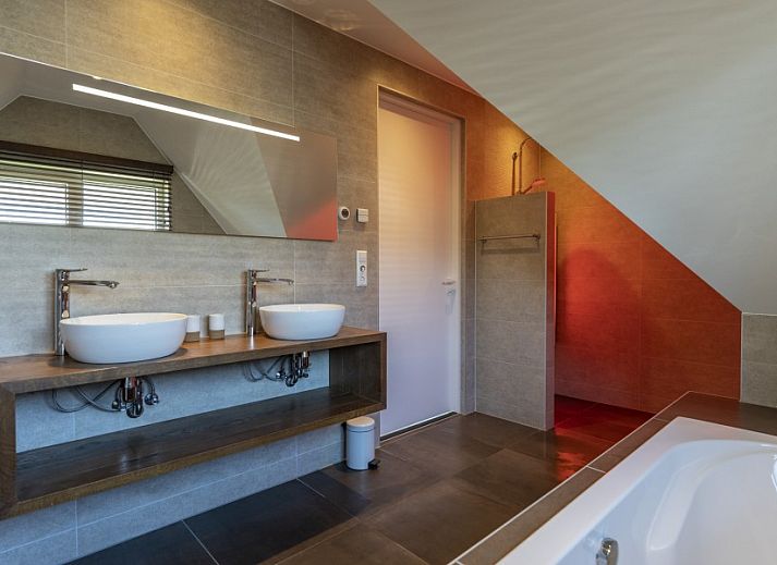 Stijlvolle entree van Villa 8 Pers. op Vakantiepark So What, Texel met houten trap en kunstzinnige muurschildering.