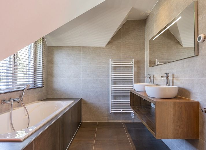 Stijlvolle entree van Villa 8 Pers. op Vakantiepark So What, Texel met houten trap en kunstzinnige muurschildering.