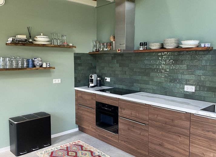 Buitenzijde van vakantiehuis Paal 234 in De Koog, Texel, omgeven door groene natuur.