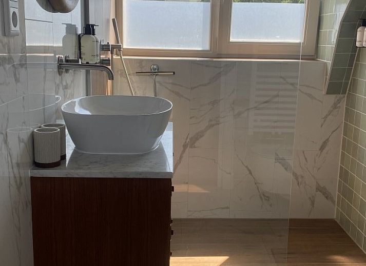 Stijlvolle woonkamer van Paal 234, een vakantiehuis in De Koog, Texel, met leren bank en vintage decor.