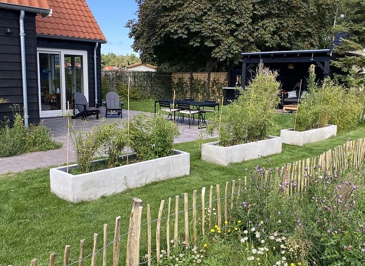 Lichte leefruimte in vakantiehuis Paal 234, De Koog, Texel, met comfortabele stoelen en grote ramen.