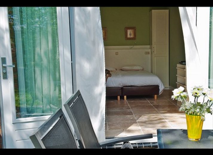 Gezellige slaapkamer met terras bij B&B Nederlof in De Cocksdorp, Texel. Ontspan in de natuurlijke omgeving van de Waddeneilanden.