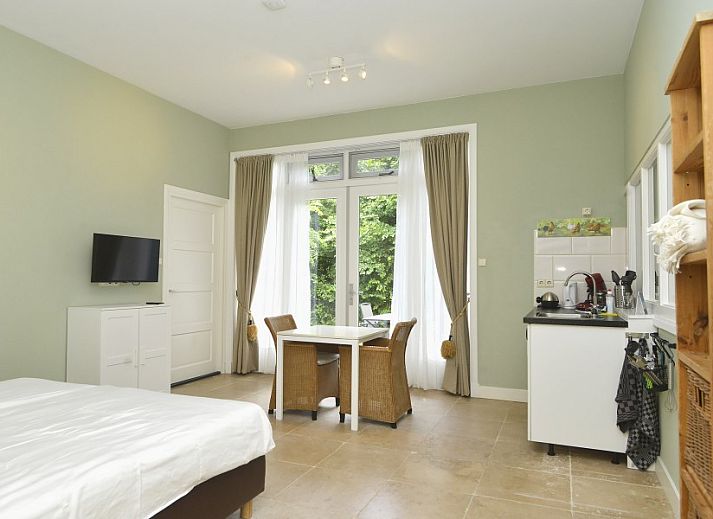 Gezellige slaapkamer met terras bij B&B Nederlof in De Cocksdorp, Texel. Ontspan in de natuurlijke omgeving van de Waddeneilanden.