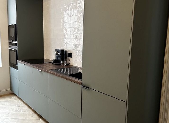 Stijlvolle woonkamer in Villa Frans Luxe Appartement, Oostende, met comfortabele bank en grote ramen.