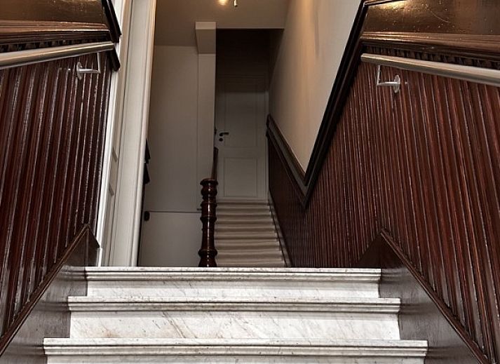 Gezellige leeshoek in Villa Frans Luxe Appartement, Oostende, met comfortabele stoel en sfeervolle lamp.