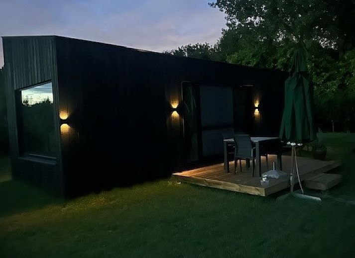 Slaapkamer in Black Pearl vakantiehuis, Moerzeke, Oost-Vlaanderen, met grote ramen en uitzicht op natuur.