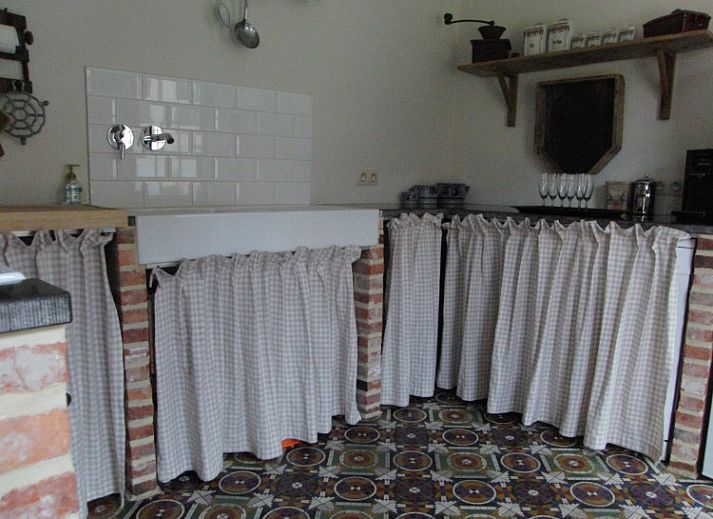 Sfeervolle slaapkamer in 't Nophof vakantiehuis Kluisbergen-Zulzeke, Oost-Vlaanderen, met houten vloer en rustieke inrichting.