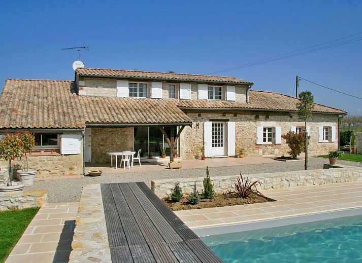 Eetkamer van Saphir vakantiehuis in Saint-Sylvestre-sur-Lot, Aquitaine, met een uitnodigende open haard en stijlvol gedekte tafel.
