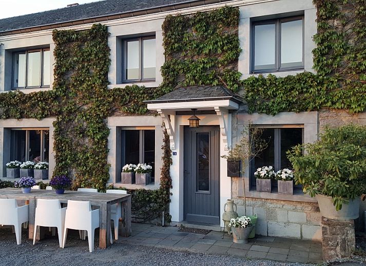 Charming vacation home Au Foyer in Durbuy, Ardennes with green facade and inviting terrace.
