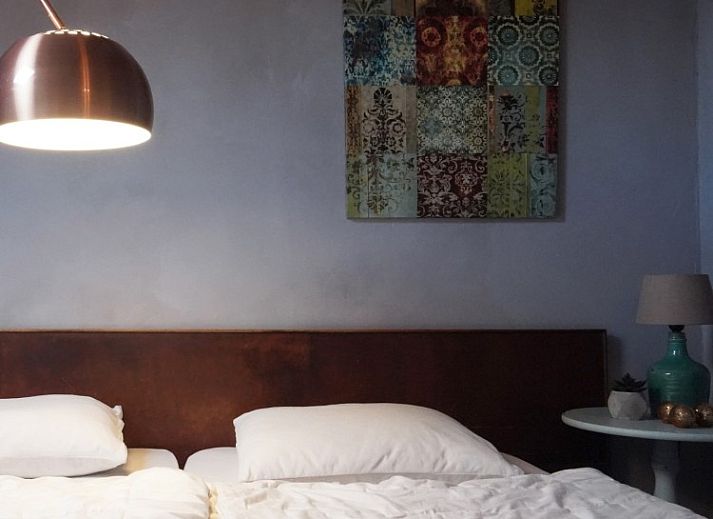 Atmospheric living room in vacation home Au Foyer, Durbuy, with artwork and soft lighting.