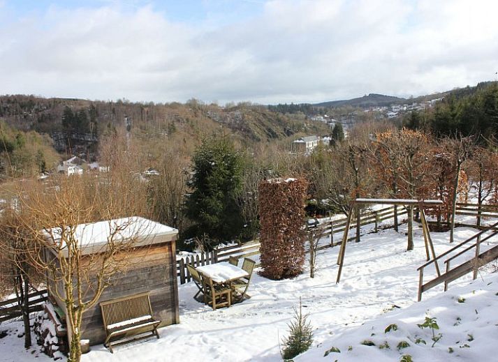 Comfortabele woonkamer in Dogo In Paradise vakantiehuis, Houffalize, Ardennen, met grote ramen en houtkachel.