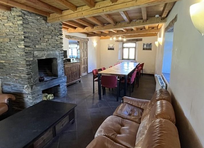 Vakantiehuis Het Huis Hiernaast in Houffalize, Ardennen, met houtstapel op de voorgrond.