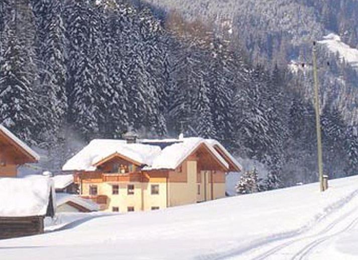 Woonkamer van Fintinn in Huttschlag, Salzburg, vakantiehuis met knusse zithoek en houten eettafel.