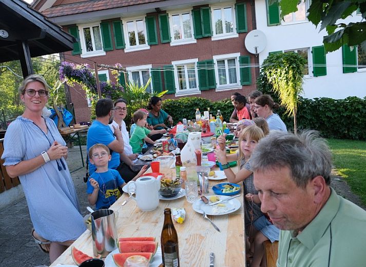 Knusse slaapruimte in Hauschen, Winikon, Zwitserland, met sfeervolle houten elementen en uitnodigende bedden.