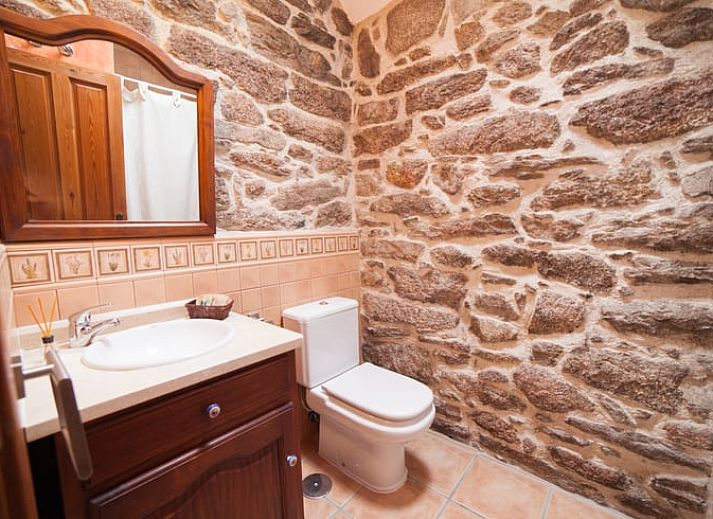Rustieke charme in Vakantiehuis in A Lama, Het groene Spanje, met een uitnodigende slaapkamer en authentieke stenen details.