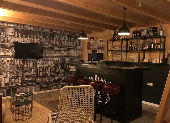 Gezellige binnenruimte van Vakantiehuis in 't Harde, Veluwe, met houten interieur en zitgedeelte.