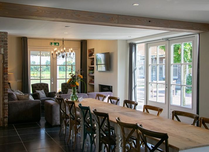 Veranda van Vakantiehuisje in Evertsoord, Noord Limburg met houten tafel en stoelen voor een gezellige buitenmaaltijd.