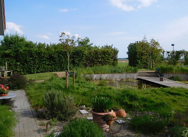 Entrance to Holiday home in Dreischor, a charming vacation home in Schouwen-Duiveland, Zeeland, with colorful flowers by the door.