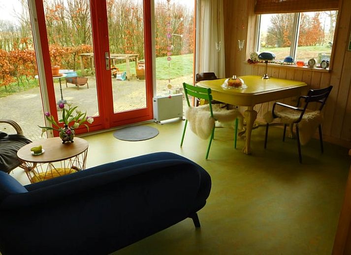 View from the window of Holiday Home in Dreischor, a vacation home in Schouwen-Duiveland, Zeeland, with a green garden and pond.