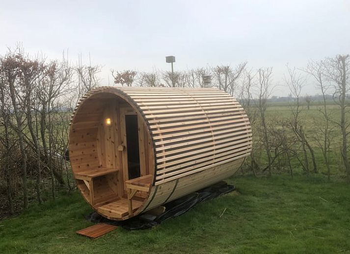 Exterior of Holiday home in Dreischor, an attractive vacation home in Schouwen-Duiveland, Zeeland, with a beautiful garden and blue sky.